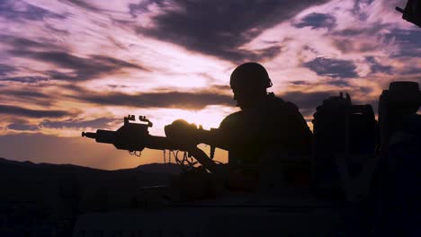 Silhouette-Eines-Soldaten-Auf-Einem-Maschinengewehr-Auf-Einem-Panzer-Gegen-Einen-Sonnenuntergang-2019