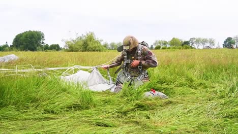 A-Paratrooper-Has-He-Removes-His-Parachute-After-Landing-In-A-Field-Near-Saintemereeglise-France-For-the-75th-Commemoration-Of-Dday-June-9th-2019