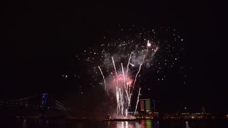 A-Fireworks-Display-Takes-Place-Over-the-Water-By-A-Bridge-In-America