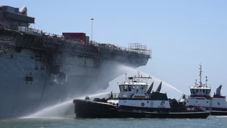 Tugboats-Spray-Water-On-the-Amphibious-Assaul-Ship-Uss-Bonhommer-Richard-To-Cool-the-Skin-And-Prevent-Flash-Fires-2