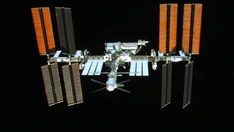 The-International-Space-Station-Flies-Against-A-Black-Background