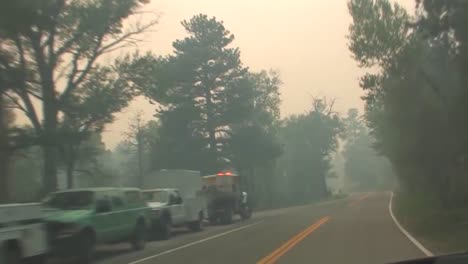 Pov-Shot-Driving-Along-A-Road-With-Smoke-From-A-Forest-Fire-Clouding-View