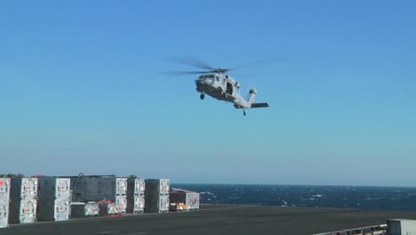 A-Navy-Helicopter-Lifts-Items-Off-The-Deck-Of-An-Aircraft-Carrier-During-A-Operation-1