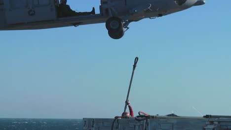 A-Navy-Helicopter-Lifts-Items-Off-The-Deck-Of-An-Aircraft-Carrier-During-A-Operation-4