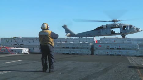 A-Navy-Helicopter-Lifts-Items-Off-The-Deck-Of-An-Aircraft-Carrier-During-A-Operation-6