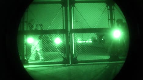 Night-Vision-Of-Men-In-Biohazard-Suits-Entering-An-Industrial-Area