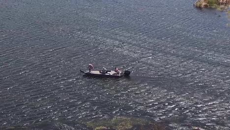 Good-Aerial-Over-Three-Fishermen-In-A-Small-Boat-Moving-Along-A-River-1