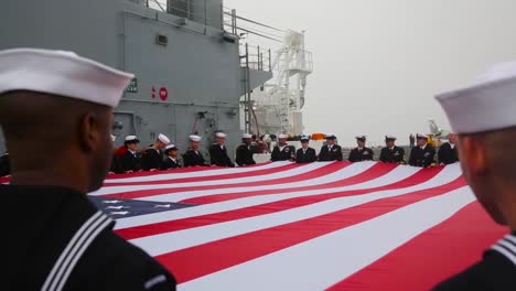 Marinepersonal-Hält-Eine-Riesige-Amerikanische-Flagge-Als-Zeichen-Von-Patriotismus