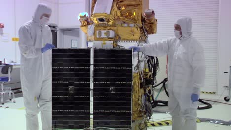 NASA-Ingenieure-Arbeiten-An-Einer-Solaranlage-Im-Weltraum-In-Einer-Streng-Kontrollierten-Reinraumumgebung