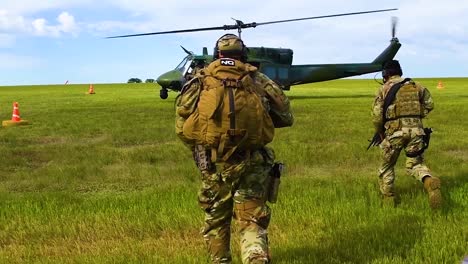 Los-Soldados-Corren-Hacia-Un-Helicóptero-Huey-En-Una-Llanura-Cubierta-De-Hierba-Con-El-Servicio-Y-Las-Fuerzas-Estadounidenses-Que-Protegen-La-Misión-En-Cámara-Lenta