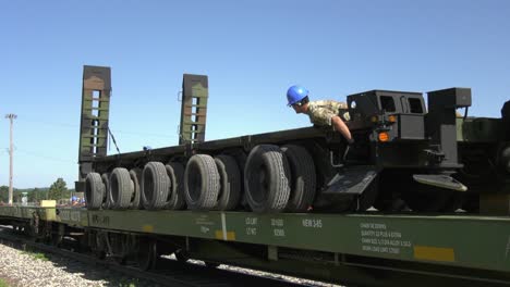 Kran-Senkt-Einen-Anhänger-Auf-Einen-Eisenbahnwagen,-Während-Soldaten-Der-1158.-Transportfirma-Wisconsin-Nat-Guard-Ihn-Positionieren