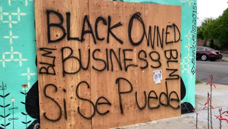Eine-Mit-Brettern-Vernagelte-Ladenfront-In-Los-Angeles-Wird-Während-Der-Proteste-Gegen-Unruhen-Und-Plünderungen-Gegen-Schwarze-Leben-Als-Ein-Geschäft-In-Schwarzbesitz-Identifiziert