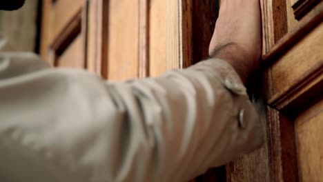 Man-Knocks-Traditional-Wooden-Door