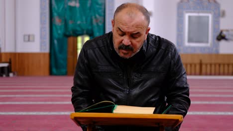 Mann-Mittleren-Alters,-Der-Den-Koran-In-Der-Moschee-Liest