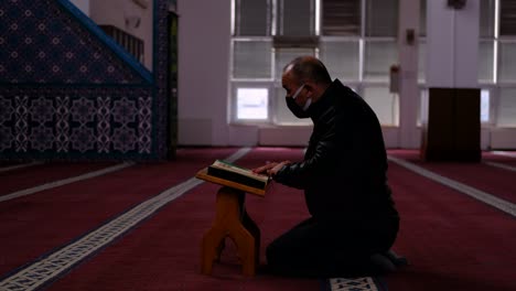 Erwachsener-Maskierter-Mann-Liest-Den-Koran-In-Der-Moschee