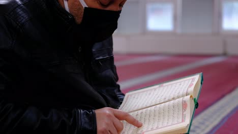 Musulmán-Leyendo-El-Libro-Sagrado-El-Corán-En-Una-Mezquita