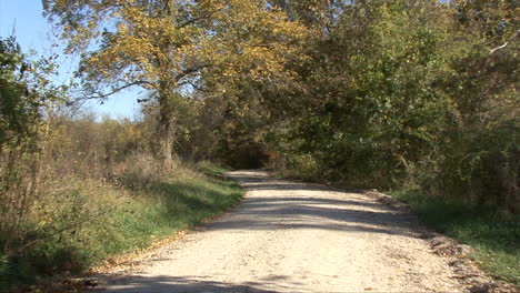 Iowa-zooms-down-a-dirt-road-in-fall