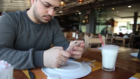 Man-Using-Mobile-Phone-In-Restaurant