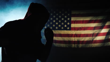 The-silhouette-of-a-fighter-trains-against-the-background-of-the-flag-of-America
