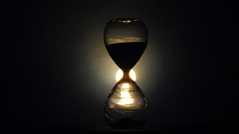 The-flickering-light-illuminates-the-old-hourglass