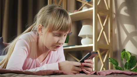 A-child-rests-in-his-room-and-uses-a-smartphone