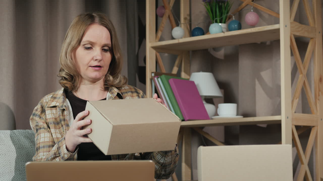 Premium stock video - A woman works at home looks through parcels ready ...