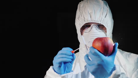 A-man-in-protective-clothing-and-gloves-takes-a-smear-from-a-large-apple-2