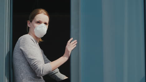 A-Sad-Woman-In-A-Mask-Peeks-Out-Of-The-Window