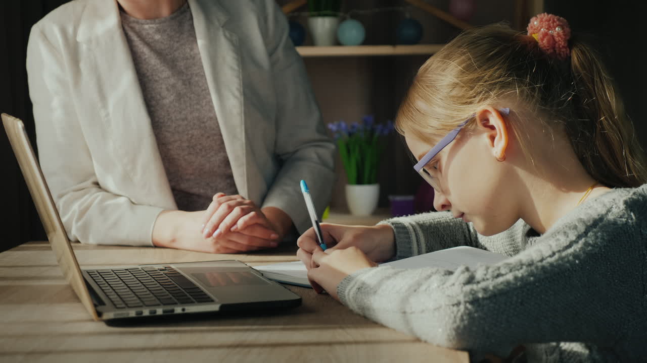 Premium stock video - Woman helps child with homework as the girl ...