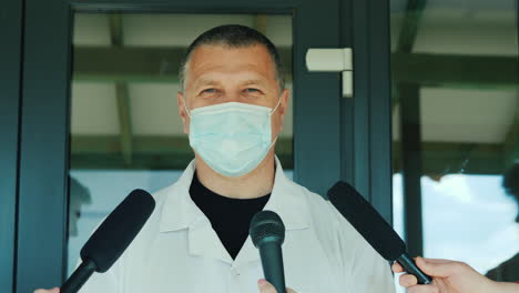 A-Doctor-In-A-Protective-Mask-Tells-The-News-To-Reporters