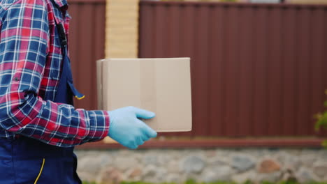 Side-View:-A-Courier-With-A-Parcel-Of-Hands-Walks-Along-The-Street