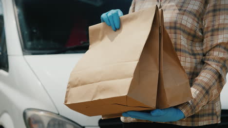 Messenger-Transfers-Bags-Of-Groceries-To-The-Recipient-Near-The-Delivery-Service-Van