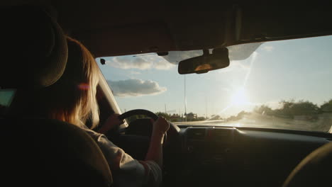 Middle-aged-female-driver-drives-car-in-setting-sun-1