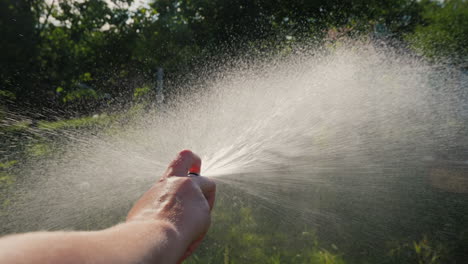 Gardener's-hand-pours-a-garden-hose-with-a-diffuser