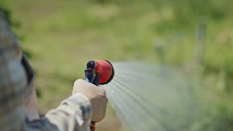 Gardener-sprays-water-from-a-garden-hose-1