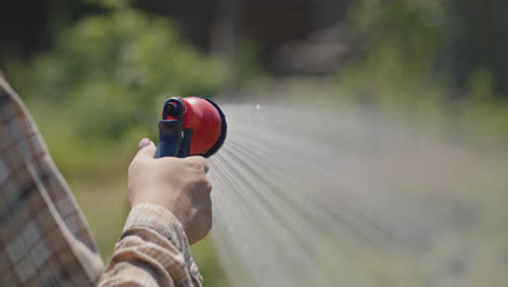 Gardener-sprays-water-from-a-garden-hose-4