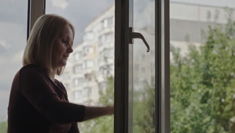 A-woman-washes-a-window-in-the-apartment-of-a-high-rise-building-2