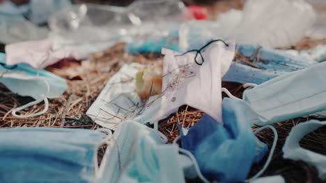 Debris-from-medical-masks-and-plastic-lies-on-the-ground-in-the-forest
