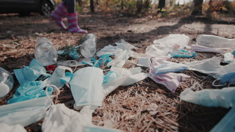 The-child's-feet-in-boots-walks-through-the-woods-past-a-pile-of-garbage