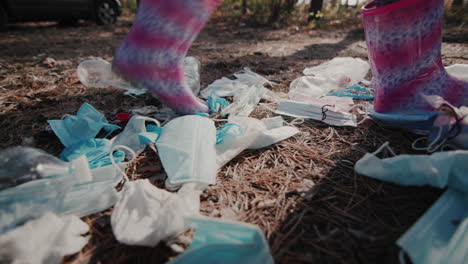 The-child's-feet-in-boots-walks-through-the-woods-past-a-pile-of-garbage-1