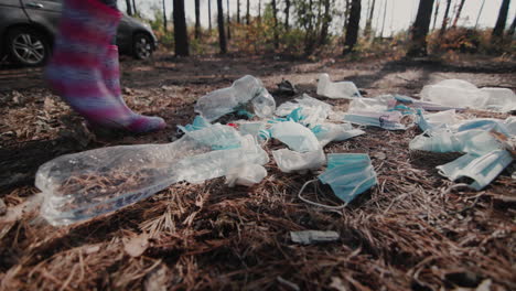 A-child-in-a-boots-walks-through-a-pile-of-garbage-in-the-forest