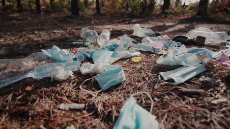 Medical-masks-and-plastic-lies-on-the-ground-in-the-forest