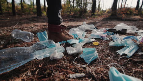 A-man-walks-through-the-woods-past-a-landfill-made-of-household-rubbish-1