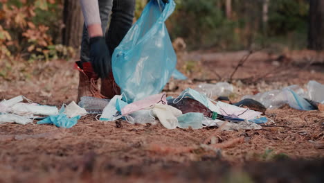 A-woman-picks-up-medical-masks-and-plastic-garbage-in-a-forest-1