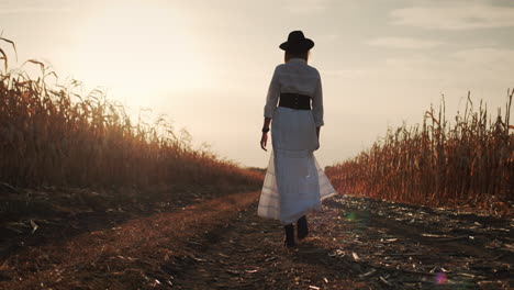 Farmer-in-a-dress-and-hat-walks-in-a-field-of-ripe-corn-3
