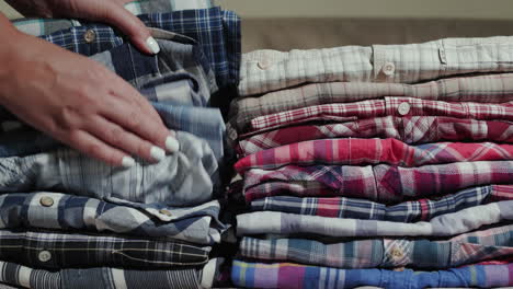 Women's-hands-sort-through-a-stack-of-men's-shirts-1