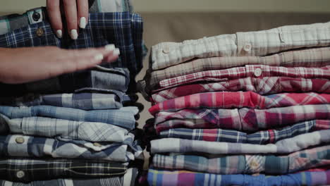 Women's-hands-sort-through-a-stack-of-men's-shirts-2