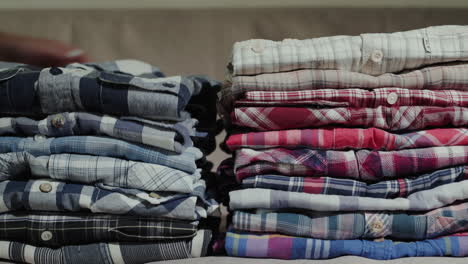 Women's-hands-put-men's-shirts-in-a-neat-pile