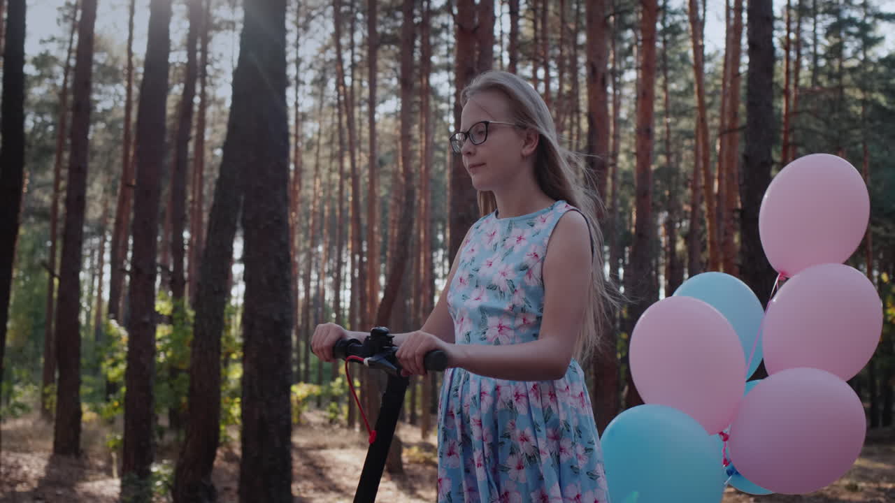Premium stock video A child on a scooter decorated with balloons