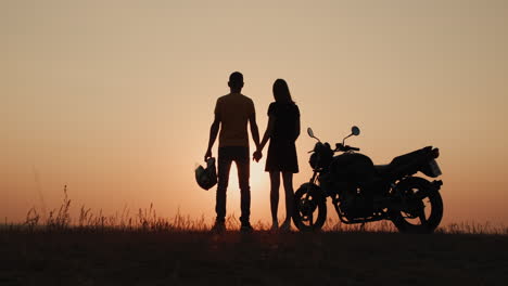 couple on motorcycle sunset